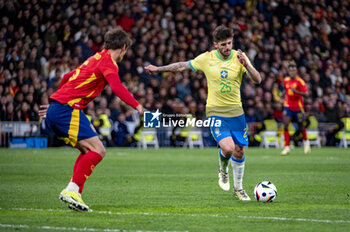 2024-03-26 - Lucas Beraldo of Brazil (L) kicks the ball during the friendly football match among the national teams of Spain and Brazil at Estadio Santiago Bernabeu, Madrid. - SPAIN VS BRAZIL - FRIENDLY MATCH - SOCCER
