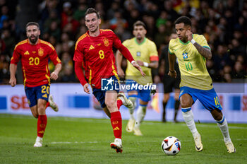 2024-03-26 - Rodrygo Goes of Brazil (R) in action with the ball against Fabian Ruiz of Spain (L) during the friendly football match among the national teams of Spain and Brazil at Estadio Santiago Bernabeu, Madrid. - SPAIN VS BRAZIL - FRIENDLY MATCH - SOCCER