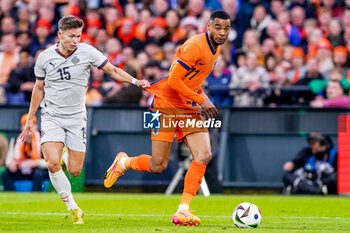 2024-06-10 - Cody Gakpo of Netherlands is challenged by Bjarki Steinn Bjarkason of Iceland during the International Friendly football match between Netherlands and Iceland on June 10, 2024 at Stadion Feijenoord de Kuip in Rotterdam, Netherlands - FOOTBALL - FRIENDLY GAME - NETHERLANDS V ICELAND - FRIENDLY MATCH - SOCCER