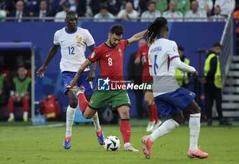 2024-07-05 - Bruno Fernandes of Portugal, left Randal Kolo Muani of France during the UEFA Euro 2024, quarter-final football match between Portugal and France on July 5, 2024 at Volksparkstadion in Hamburg, Germany - FOOTBALL - EURO 2024 - 1/4 - PORTUGAL V FRANCE - UEFA EUROPEAN - SOCCER