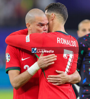 2024-07-05 - Pepe and Cristiano Ronaldo of Portugal look dejected after the UEFA Euro 2024, Quarter-finals football match between Portugal and France on July 5, 2024 at Volksparkstadion in Hamburg, Germany - FOOTBALL - EURO 2024 - 1/4 - PORTUGAL V FRANCE - UEFA EUROPEAN - SOCCER