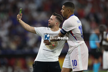 2024-07-09 - Munich , Germany 09.07.2024: fan invades the pitch to take a photograph with Kylian Mbappe of France during the UEFA EURO 2024 semi-finals, football match between Spain vs France at Munich Football Allianz Arena - UEFA EURO 2024 - SEMIFINALS - SPAIN VS FRANCE  - UEFA EUROPEAN - SOCCER