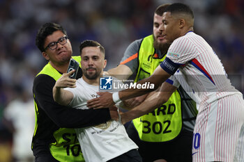 2024-07-09 - Munich , Germany 09.07.2024: fan invades the pitch to take a photograph with Kylian Mbappe of France during the UEFA EURO 2024 semi-finals, football match between Spain vs France at Munich Football Allianz Arena - UEFA EURO 2024 - SEMIFINALS - SPAIN VS FRANCE  - UEFA EUROPEAN - SOCCER