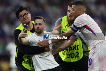 2024-07-09 - Munich , Germany 09.07.2024: fan invades the pitch to take a photograph with Kylian Mbappe of France during the UEFA EURO 2024 semi-finals, football match between Spain vs France at Munich Football Allianz Arena - UEFA EURO 2024 - SEMIFINALS - SPAIN VS FRANCE  - UEFA EUROPEAN - SOCCER