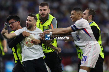 2024-07-09 - Munich , Germany 09.07.2024: fan invades the pitch to take a photograph with Kylian Mbappe of France during the UEFA EURO 2024 semi-finals, football match between Spain vs France at Munich Football Allianz Arena - UEFA EURO 2024 - SEMIFINALS - SPAIN VS FRANCE  - UEFA EUROPEAN - SOCCER