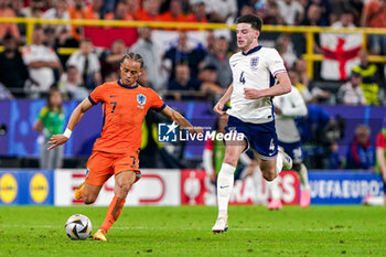 2024-07-10 - Xavi Simons of the Netherlands battles for possession with Declan Rice of England during the UEFA Euro 2024, Semi-finals football match between Netherlands and England on 10 July 2024 at Signal Iduna Park in Dortmund, Germany - FOOTBALL - EURO 2024 - 1/2 - NETHERLANDS V ENGLAND - UEFA EUROPEAN - SOCCER