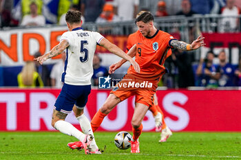 2024-07-10 - John Stones of England battles for possession with Wout Weghorst of the Netherlands during the UEFA Euro 2024, Semi-finals football match between Netherlands and England on 10 July 2024 at Signal Iduna Park in Dortmund, Germany - FOOTBALL - EURO 2024 - 1/2 - NETHERLANDS V ENGLAND - UEFA EUROPEAN - SOCCER