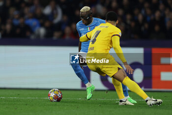 2024-02-21 - SSC Napoli's Nigerian forward Victor Osimhen challenges for the ball with Barcellona's Uruguayan defender Ronald Araujo during the UEFA Champions League round 16 match between SSC Napoli vs Barcellona at the Diego Armando Maradona Stadium in Naples, southern Italy, on February 21, 2024. - SSC NAPOLI VS FC BARCELONA - UEFA CHAMPIONS LEAGUE - SOCCER
