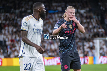 2024-04-09 - Erling Haaland of Manchester City (R) talks and laughs with Antonio Rudiger of Real Madrid (L) during the UEFA Champions League quarter-final first leg match between Real Madrid CF and Manchester City at Estadio Santiago Bernabeu on April 9, 2024 in Madrid, Spain. - REAL MADRID VS MANCHESTER CITY - UEFA CHAMPIONS LEAGUE - SOCCER