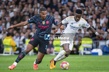 2024-04-09 - Vinicius Junior of Real Madrid (R) in action against Manuel Akanji of Manchester City (L) during the UEFA Champions League quarter-final first leg match between Real Madrid CF and Manchester City at Estadio Santiago Bernabeu on April 9, 2024 in Madrid, Spain. - REAL MADRID VS MANCHESTER CITY - UEFA CHAMPIONS LEAGUE - SOCCER
