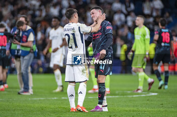 2024-04-09 - Brahim Diaz of Real Madrid (L) hugs Phil Foden of Manchester City (R) during the UEFA Champions League quarter-final first leg match between Real Madrid CF and Manchester City at Estadio Santiago Bernabeu on April 9, 2024 in Madrid, Spain. - REAL MADRID VS MANCHESTER CITY - UEFA CHAMPIONS LEAGUE - SOCCER