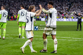 2024-05-08 - MADRID, SPAIN - MAY 8: Jude Bellingham (R) and Luka Modric (L) of Real Madrid seen celebrating the victory at the end of the UEFA Champions League semi-final second leg match between Real Madrid and FC Bayern Munchen at Estadio Santiago Bernabeu on May 8, 2024 in Madrid, Spain. - REAL MADRID VS BAYERN MUNICH - UEFA CHAMPIONS LEAGUE - SOCCER