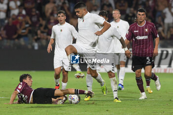 2024-08-12 - Giuseppe Aurelio of Spezia Calcio competes for the ball with Lilian Njoh of US Salernitana 1919 during the Soccer Italian Cup Freccia Rossa between US Salernitana 1919 vs Spezia Calcio at Arechi Stadium - US SALERNITANA VS SPEZIA CALCIO - ITALIAN CUP - SOCCER