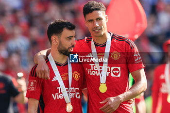 2024-05-25 - Bruno Fernandes (8) and Raphael Varane (19) of Manchester United celebrate after the 1-2 victory during the English FA Cup, Final football match between Manchester City and Manchester United on 25 May 2024 at Wembley Stadium in London, England - FOOTBALL - ENGLISH CUP - FINAL - MANCHESTER CITY V MANCHESTER UNITED - ENGLISH LEAGUE CUP - SOCCER