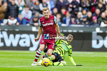 2024-02-12 - Gabriel Martinelli (11) of Arsenal slides in and tackles James Ward-Prowse (7) of West Ham during the English championship Premier League football match between West Ham United and Arsenal on 11 February 2024 at the London Stadium in London, England - FOOTBALL - ENGLISH CHAMP - WEST HAM V ARSENAL - ENGLISH PREMIER LEAGUE - SOCCER