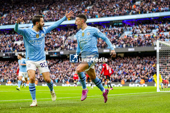 2024-03-04 - Phil Foden (47) of Manchester City scores a goal and celebrates 2-1 with Bernardo Silva during the English championship Premier League football match between Manchester City and Manchester United on 3 March 2024 at the Etihad Stadium in Manchester, England - FOOTBALL - ENGLISH CHAMP - MANCHESTER CITY V MANCHESTER UNITED - ENGLISH PREMIER LEAGUE - SOCCER