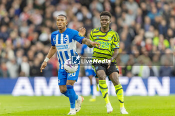 2024-04-06 - Brighton & Hove Albion FC defender Pervis Estupinán (30) and Arsenal FC midfielder Bukayo Saka during the English championship Premier League football match between Brighton and Hove Albion and Arsenal on 6 April 2024 at the American Express Stadium in Brighton and Hove, England - FOOTBALL - ENGLISH CHAMP - BRIGHTON V ARSENAL - ENGLISH PREMIER LEAGUE - SOCCER