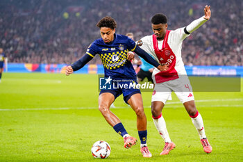 2024-11-07 - Tyrese Asante of Maccabi Tel Aviv battles for possession with Jorrel Hato of AFC Ajax during the UEFA Europa League, League Phase, MD4 football match between AFC Ajax and Maccabi Tel Aviv on November 7, 2024 at Johan Cruijff ArenA in Amsterdam, Netherlands - FOOTBALL - EUROPA LEAGUE - AJAX V MACCABI TEL AVIV - UEFA EUROPA LEAGUE - SOCCER