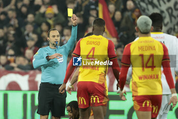 2024-01-14 - Referee Jerome Brisard gives a yellow card during the French championship Ligue 1 football match between RC Lens and Paris Saint-Germain on January 14, 2024 at Stade Bollaert-Delelis in Lens, France - FOOTBALL - FRENCH CHAMP - LENS V PARIS SG - FRENCH LIGUE 1 - SOCCER