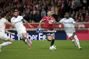 2024-04-05 - Remy Cabella of Lille between Samuel Gigot and Ulisses Garcia of Marseille during the French championship Ligue 1 football match between Lille OSC (LOSC) and Olympique de Marseille (OM) on April 5, 2024 at Stade Pierre Mauroy in Villeneuve-d'Ascq near Lille, France - FOOTBALL - FRENCH CHAMP - LILLE V MARSEILLE - FRENCH LIGUE 1 - SOCCER