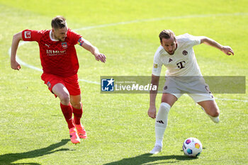 2024-04-06 - Harry Kane of Bayern Munich and Patrick Mainka of Heidenheim during the German championship Bundesliga football match between FC Heidenheim and FC Bayern Munich on April 6, 2024 at Voith Arena in Heidenheim, Germany - FOOTBALL - GERMAN CHAMP - HEIDENHEIM V BAYERN MUNICH - GERMAN BUNDESLIGA - SOCCER