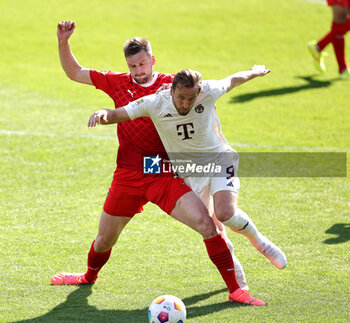 2024-04-06 - Harry Kane of Bayern Munich and Patrick Mainka of Heidenheim during the German championship Bundesliga football match between FC Heidenheim and FC Bayern Munich on April 6, 2024 at Voith Arena in Heidenheim, Germany - FOOTBALL - GERMAN CHAMP - HEIDENHEIM V BAYERN MUNICH - GERMAN BUNDESLIGA - SOCCER