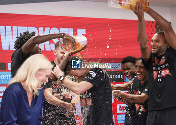 2024-04-14 - Head coach Xabi Alonso is showered with beer by his players during the post-match press conference to celebrate the 2024 German championship after the German championship Bundesliga football match between Bayer Leverkusen and Werder Bremen on April 14, 2024 at BayArena in Leverkusen, Germany - FOOTBALL - GERMAN CHAMP - LEVERKUSEN V BREMEN - GERMAN BUNDESLIGA - SOCCER