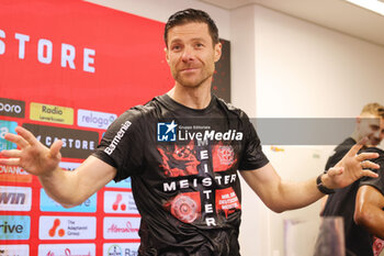 2024-04-14 - Head coach Xabi Alonso is showered with beer by his players during the post-match press conference to celebrate the 2024 German championship after the German championship Bundesliga football match between Bayer Leverkusen and Werder Bremen on April 14, 2024 at BayArena in Leverkusen, Germany - FOOTBALL - GERMAN CHAMP - LEVERKUSEN V BREMEN - GERMAN BUNDESLIGA - SOCCER