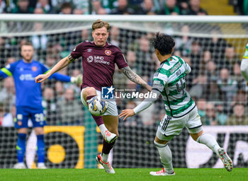 04/05/2024 - Frankie Kent of Hearts clears the ball ahead of Rey Hatate of Celtic during the Scottish championship Premiership football match between Celtic and Heart of Midlothian on 4 May 2024 at Celtic Park IN Glasgow, Scotland - FOOTBALL - SCOTTISH CHAMP - CELTIC V HEART OF MIDLOTHIAN - SCOTTISH PREMIERSHIP - CALCIO