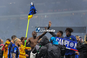 2024-04-22 - Marcus Thuram of FC Internazionale exhibits his match jersey on an AC Milan branded corner flag as he celebrates the club's 20th Scudetto with team mates during Serie A 2023/24 football match between AC Milan and FC Internazionale at San Siro Stadium, Milan, Italy on April 22, 2024 - AC MILAN VS INTER - FC INTERNAZIONALE - ITALIAN SERIE A - SOCCER
