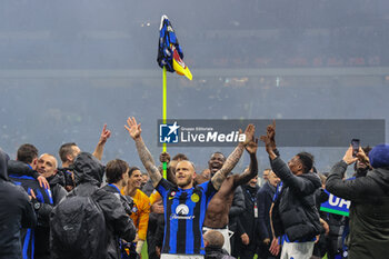 2024-04-22 - Federico Dimarco of FC Internazionale celebrates and Marcus Thuram of FC Internazionale exhibits his match jersey on an AC Milan branded corner flag as he celebrates the club's 20th Scudetto with team mates during Serie A 2023/24 football match between AC Milan and FC Internazionale at San Siro Stadium, Milan, Italy on April 22, 2024 - AC MILAN VS INTER - FC INTERNAZIONALE - ITALIAN SERIE A - SOCCER