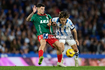 2024-01-02 - Javi Lopez of Deportivo Alaves competes for the ball with Takefusa Kubo of Real Sociedad during the Spanish championship La Liga football match between Real Sociedad and Deportivo Alaves on January 2, 2024 at Reale Arena in San Sebastian, Spain - FOOTBALL - SPANISH CHAMP - REAL SOCIEDAD V ALAVES - SPANISH LA LIGA - SOCCER