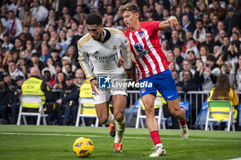 2024-02-04 - Jude Bellingham (L) of Real Madrid seen in action against Marcos Llorente (R) of Atletico Madrid during the La Liga EA Sports 2023/24 football match between Real Madrid vs Atletico Madrid at Santiago Bernabeu stadium in Madrid, Spain. - REAL MADRID VS ATLETICO MADRID - SPANISH LA LIGA - SOCCER