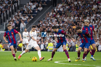 2024-04-21 - MADRID, SPAIN - APRIL 21: Brahim Diaz of Real Madrid seen in action with the ball against FC Barcelona defenders during the La Liga EA Sports 2023/24 football match between Real Madrid vs FC Barcelona at Estadio Santiago Bernabeu on April 21, 2024 in Madrid, Spain. - REAL MADRID VS FC BARCELONA - SPANISH LA LIGA - SOCCER