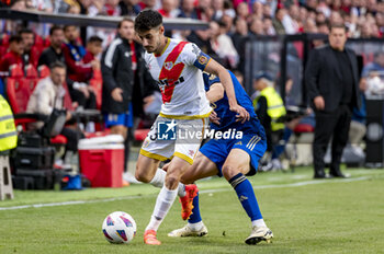 2024-05-15 - Oscar Valentin of Rayo Vallecano (L) in action with the ball against Facundo Pellistri of Granada CF (R) during the La Liga EA Sports 2023/24 football match between Rayo Vallecano vs Granada CF at Estadio de Vallecas on May 15, 2024 in Madrid, Spain. - RAYO VALLECANO VS GRANADA CF - SPANISH LA LIGA - SOCCER