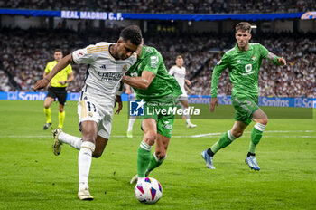 2024-05-25 - Rodrygo Silva de Goes of Real Madrid (L) in action with the ball against Marc Roca of Real Betis (R) during the La Liga EA Sports 2023/24 football match between Real Madrid vs Real Betis at Estadio Santiago Bernabeu on May 25, 2024 in Madrid, Spain. - REAL MADRID VS REAL BETIS - SPANISH LA LIGA - SOCCER