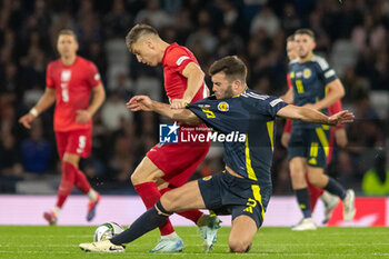 2024-09-05 - Krzysztof Piątek of Poland & Grant Hanley of Scotland during the UEFA Nations League match between Scotland and Poland. The National Stadium, Hampden Park, Glasgow, Scotland. 05/09/2024. Photo Colin Poultney /ProSportsImages / DPPI - FOOTBALL - UEFA NATIONS LEAGUE - SCOTLAND V POLAND - UEFA NATIONS LEAGUE - SOCCER