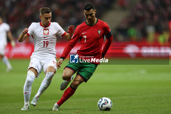 2024-10-12 - Przemyslaw Frankowski of Poland and Cristiano Ronaldo of Portugal during the UEFA Nations League, League A, Group A1 football match between Poland and Portugal on 12 October 2024 at PGE Narodowy in Warsaw, Poland - FOOTBALL - UEFA NATIONS LEAGUE - POLAND V PORTUGAL - UEFA NATIONS LEAGUE - SOCCER