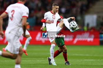 2024-10-12 - Sebastian Szymanski of Poland and Bernardo Silva of Portugal during the UEFA Nations League, League A, Group A1 football match between Poland and Portugal on 12 October 2024 at PGE Narodowy in Warsaw, Poland - FOOTBALL - UEFA NATIONS LEAGUE - POLAND V PORTUGAL - UEFA NATIONS LEAGUE - SOCCER