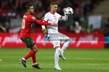 2024-10-12 - Bernardo Silva of Portugal and Sebastian Szymanski of Poland during the UEFA Nations League, League A, Group A1 football match between Poland and Portugal on 12 October 2024 at PGE Narodowy in Warsaw, Poland - FOOTBALL - UEFA NATIONS LEAGUE - POLAND V PORTUGAL - UEFA NATIONS LEAGUE - SOCCER