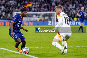 2024-10-14 - Jeremie Frimpong of Netherlands is challenged by Maximilian Mittelstädt of Germany during the UEFA Nations League, League A, Group 3 football match between Germany and Netherlands on October 14, 2024 at Allianz Arena in Munich, Germany - FOOTBALL - UEFA NATIONS LEAGUE - GERMANY V NETHERLANDS - UEFA NATIONS LEAGUE - SOCCER