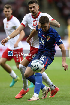 2024-10-15 - Jakub Moder of Poland and Martin Baturina of Croatia during the UEFA Nations League, League A, Group A1 football match between Poland and Croatia on 15 October 2024 at PGE Narodowy stadium in Warsaw, Poland - FOOTBALL - UEFA NATIONS LEAGUE - POLAND V CROATIA - UEFA NATIONS LEAGUE - SOCCER