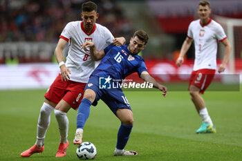 2024-10-15 - Jakub Moder of Poland and Martin Baturina of Croatia during the UEFA Nations League, League A, Group A1 football match between Poland and Croatia on 15 October 2024 at PGE Narodowy stadium in Warsaw, Poland - FOOTBALL - UEFA NATIONS LEAGUE - POLAND V CROATIA - UEFA NATIONS LEAGUE - SOCCER