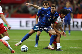 2024-10-15 - Martin Baturina of Croatia and Maximillian Oyedele of Poland during the UEFA Nations League, League A, Group A1 football match between Poland and Croatia on 15 October 2024 at PGE Narodowy stadium in Warsaw, Poland - FOOTBALL - UEFA NATIONS LEAGUE - POLAND V CROATIA - UEFA NATIONS LEAGUE - SOCCER