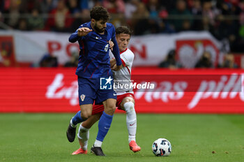 2024-10-15 - Josko Gvardiol of Croatia and Kacper Urbanski of Poland during the UEFA Nations League, League A, Group A1 football match between Poland and Croatia on 15 October 2024 at PGE Narodowy stadium in Warsaw, Poland - FOOTBALL - UEFA NATIONS LEAGUE - POLAND V CROATIA - UEFA NATIONS LEAGUE - SOCCER