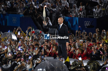 2024-07-26 - Zinadine Zidane with the Olympic torch, Opening Ceremony during the Olympic Games Paris 2024 on 26 July 2024 in Paris, France - OLYMPIC GAMES PARIS 2024 - OPENING CEREMONY - 26/07 - OLYMPIC GAMES PARIS 2024 - OLYMPIC GAMES