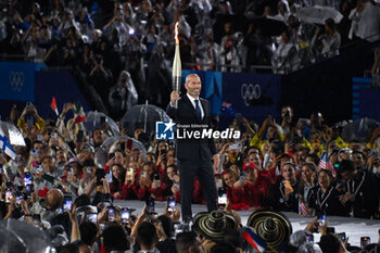 2024-07-26 - Zinadine Zidane with the Olympic torch, Opening Ceremony during the Olympic Games Paris 2024 on 26 July 2024 in Paris, France - OLYMPIC GAMES PARIS 2024 - OPENING CEREMONY - 26/07 - OLYMPIC GAMES PARIS 2024 - OLYMPIC GAMES