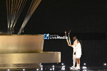 2024-07-26 - Teddy Riner and Marie-José Pérec light the Olympic cauldron, Opening Ceremony during the Olympic Games Paris 2024 on 26 July 2024 in Paris, France - OLYMPIC GAMES PARIS 2024 - OPENING CEREMONY - 26/07 - OLYMPIC GAMES PARIS 2024 - OLYMPIC GAMES