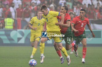 2024-07-27 - Igor Krasnopir (Ukraine) and Oussama Targhalline (Morocco), Football, Men's Group B between Ukraine and Morocco during the Olympic Games Paris 2024 on 27 July 2024 at Geoffroy-Guichard Stadium in Saint-Etienne, France - OLYMPIC GAMES PARIS 2024 - 27/07 - OLYMPIC GAMES PARIS 2024 - OLYMPIC GAMES