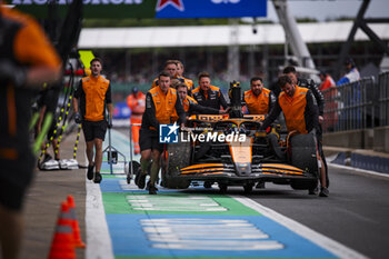 2024-07-05 - PIASTRI Oscar (aus), McLaren F1 Team MCL38 and mechanic, mecanicien, mechanics, pitlane, during the Formula 1 Qatar Airways British Grand Prix 2024, 12th round of the 2024 Formula One World Championship from July 5 to 7, 2024 on the Silverstone Circuit, in Silverstone, United Kingdom - F1 - BRITISH GRAND PRIX 2024 - FORMULA 1 - MOTORS